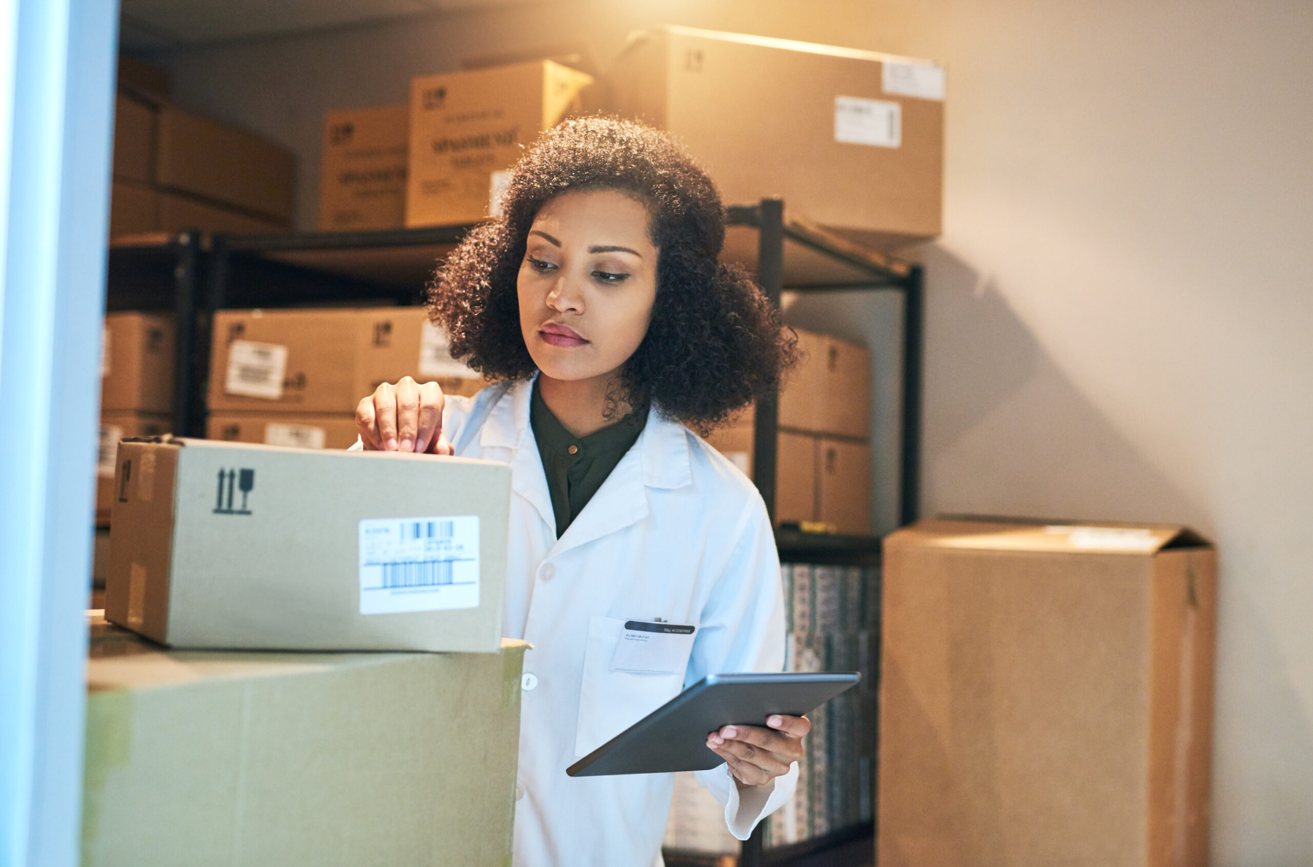 Shot of a young woman using a digital tablet while doing inventory in the storeroom of a pharmacy